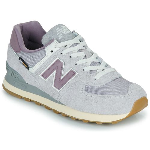 Sneakers basse New Balance 574 Donna in colore grigio, caratterizzate da un design sportivo e moderno, perfette per il comfort quotidiano. Queste scarpe offrono una suola ammortizzata e un look versatile, ideali per ogni occasione. Acquista le New Balance 574 per un perfetto mix di stile e funzionalità.